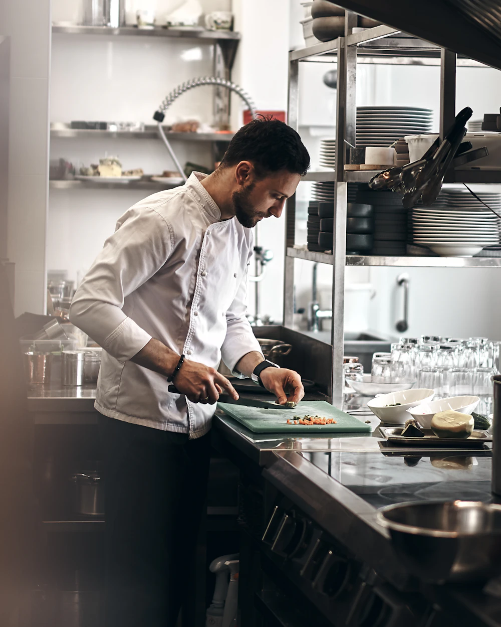 A chef chopping vegetables in a restaurant kitchen